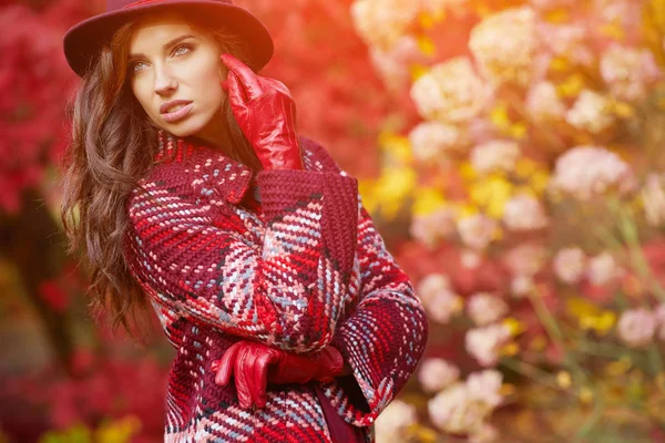 Woman in warm coat and hat in park — Stock Photo, Image