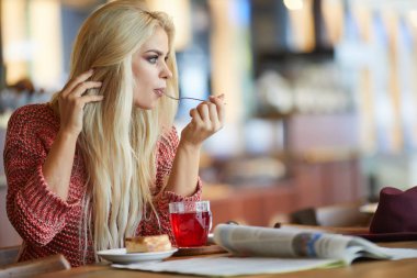 Güzel bir genç sarışın kadının çay bardağı portresi.