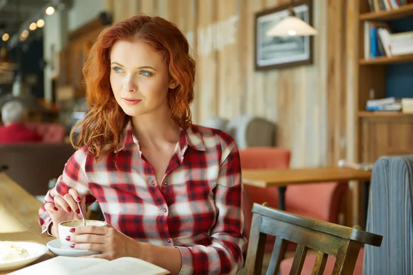 コーヒー ショップで赤髪の女性の読書を笑顔 — ストック写真