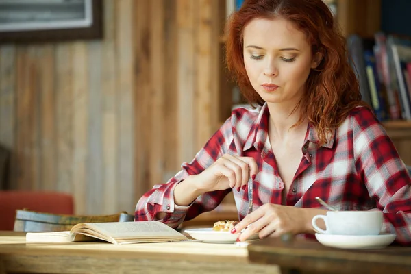Sorrindo cabelo vermelho mulher ler livro no café — Fotografia de Stock