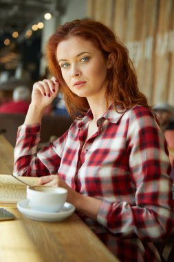 Kırmızı saçlı kadın Cafe kitap okumak. Şehir sonu kavramı