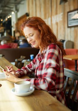 Kırmızı saçlı kadın Cafe kitap okumak. Şehir sonu kavramı