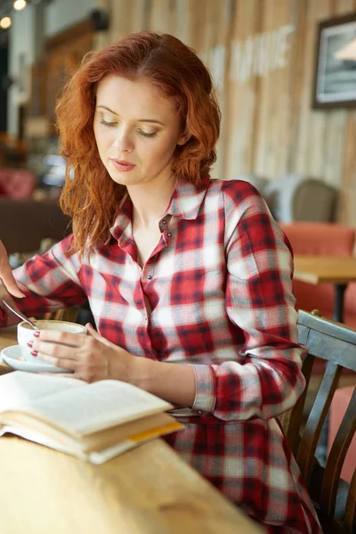 Mulher ruiva lendo livro no café. Conceito de City break — Fotografia de Stock