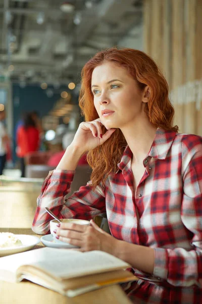 红头发的女人在咖啡馆里看书。城市休息概念 — 图库照片