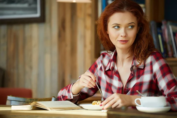Rødhåret kvinne leser bok på kafeen. Bybruddskonsept – stockfoto
