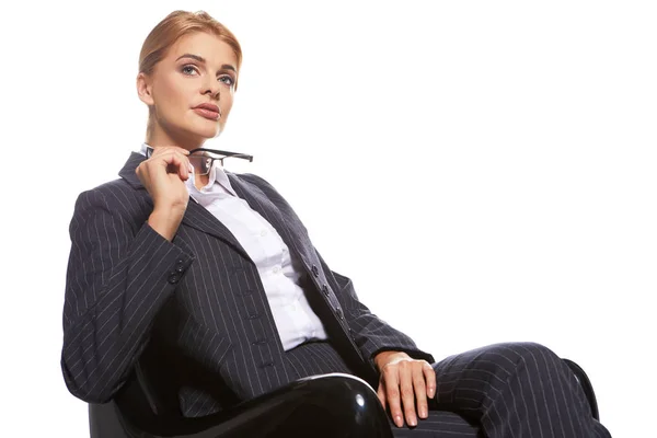 Mujer de negocios rubia sentada silla negra aislada en blanco — Foto de Stock