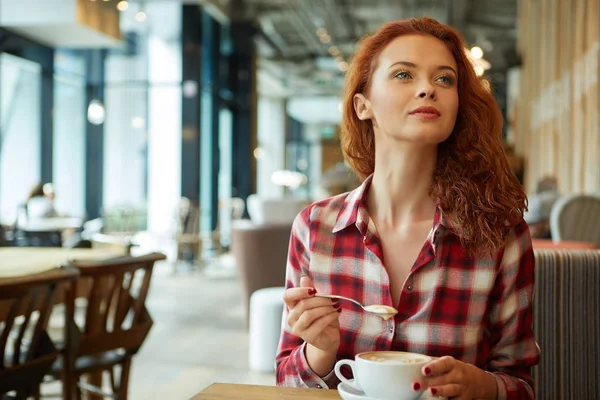 Mutlu genç bayan kahve içiyor. 