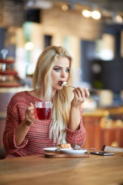 Bir kafede oturan genç ve güzel kadın  