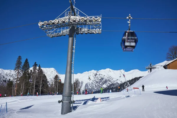 Sciatori sulla seggiovia - stazione sciistica durante la giornata di sole invernale — Foto Stock