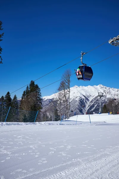 Esquiadores en el telesilla - estación de esquí durante el día soleado de invierno —  Fotos de Stock