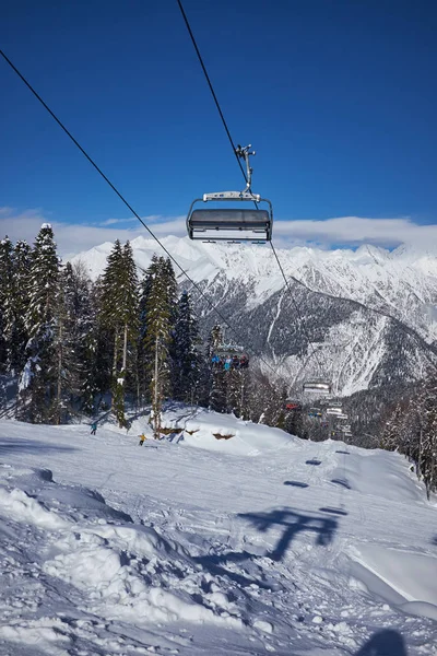 Skidåkare på liften - skidort under solig vinterdag — Stockfoto