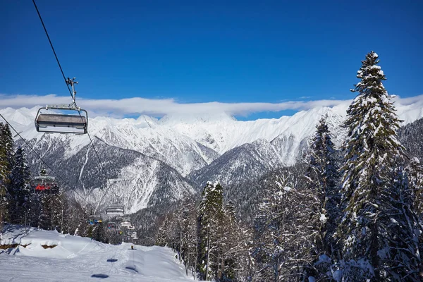 Skieurs sur le télésiège - station de ski pendant la journée ensoleillée d'hiver — Photo