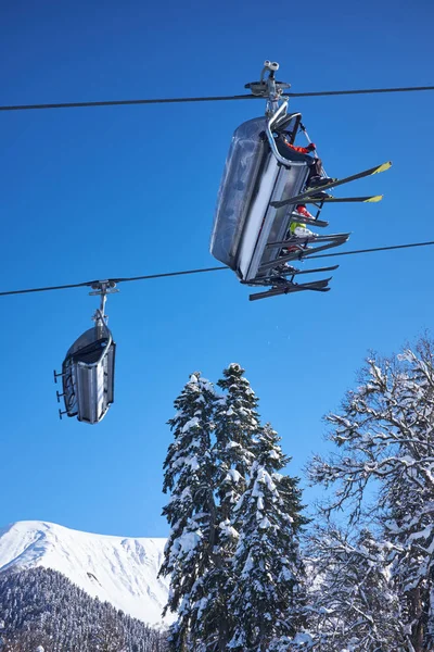 Skieurs sur le télésiège - station de ski pendant la journée ensoleillée d'hiver — Photo