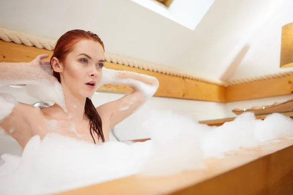 Die Frau nimmt ein Bad im Schaum — Stockfoto