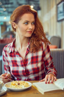 Güzel genç öğrenci eğitim veya sınavlarına bir kafede hazırlama. 