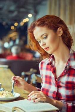 Güzel genç öğrenci eğitim veya sınavlarına bir kafede hazırlama. 