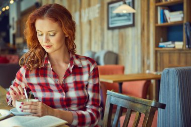 Güzel genç öğrenci eğitim veya sınavlarına bir kafede hazırlama. 