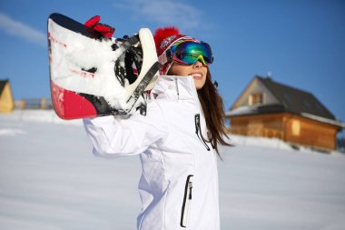 Sportif erkek snowboard dağlarda tutar.