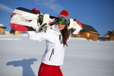 Sportif erkek snowboard dağlarda tutar.