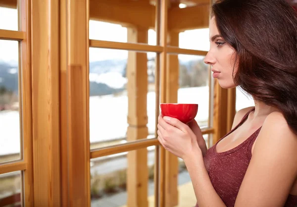 Όμορφο χειμώνα γυναίκα με ένα αρωματικό ζεστό καφεδάκι στα χέρια. — Φωτογραφία Αρχείου