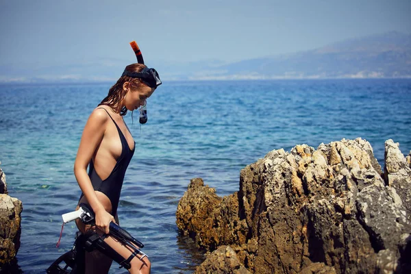 ビキニを着てアドリア海の海岸の岩にポーズをとって 代の若い大人のスリム女性 トーンのイメージ — ストック写真