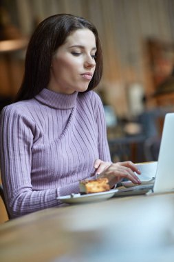 Güzel esmer kafede dizüstü bilgisayar kullanarak. Blogger iş kavramı