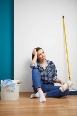 Mutlu güzel bir kadın duvar boyuyor.