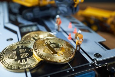 Küçük bir madenci altın sikke ile grafik kartı eşeliyor. Bitcoin madenciliği ve kripto para birimi kavramı.