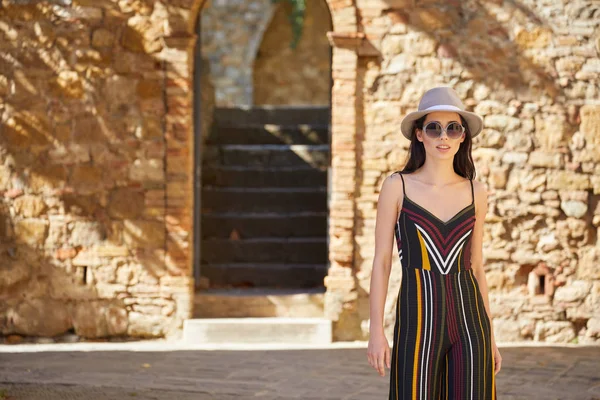 çekici kadın turist eski İtalyan kasabasında şapkalı