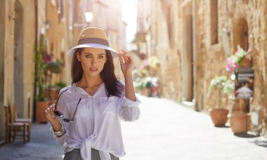 çekici kadın turist eski İtalyan kasabasında şapkalı