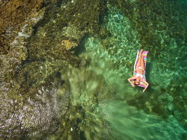 Denizde bir yatak üzerinde bikini güzel bir genç kadının havadan görünümü