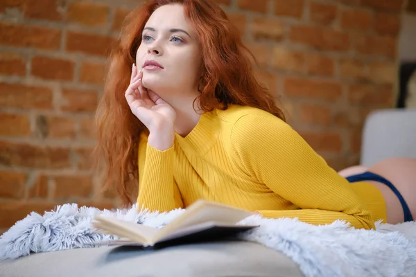 Donna dai capelli rossi legge un libro a casa — Foto Stock