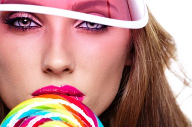 Plastik şapkalı kız lolipop tutuyor.