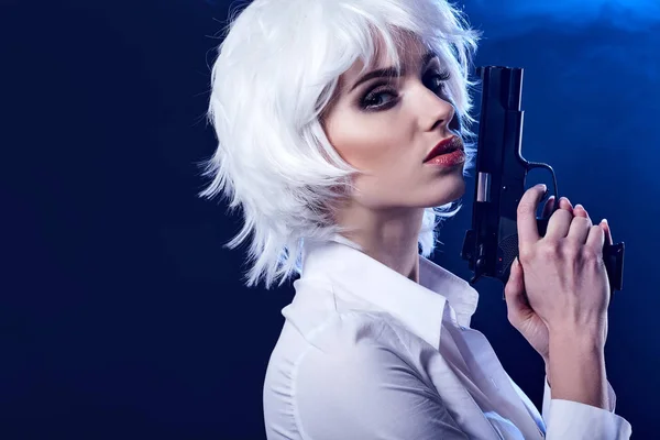 Красива сексуальна дівчина тримає пістолет. дим фон — стокове фото