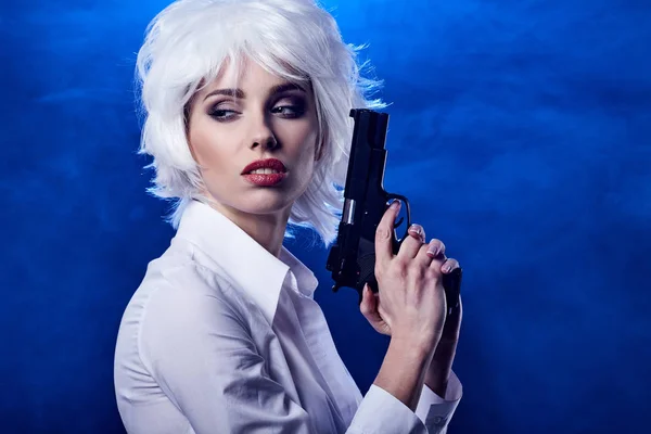 Beautiful sexy girl holding gun . smoke background — Stock Photo, Image