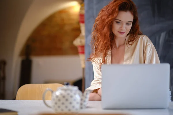 Jonge vrouw draagt een kamerjas comfortabel zittend met schoot — Stockfoto