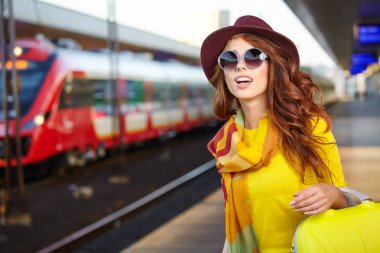 Tren istasyonunda güzel bir genç kadın (sonbahar tonu görüntüsü))