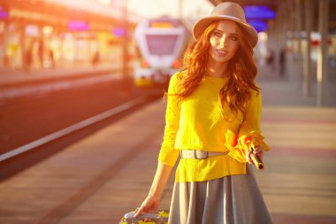 Tren istasyonunda güzel bir genç kadın (sonbahar tonu görüntüsü))