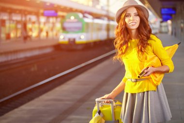 Tren istasyonunda güzel bir genç kadın (sonbahar tonu görüntüsü))