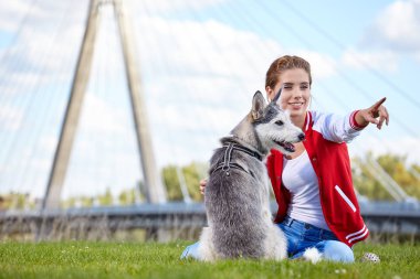 Şehrin bahçesinde köpeğiyle oynayan bir kadın.