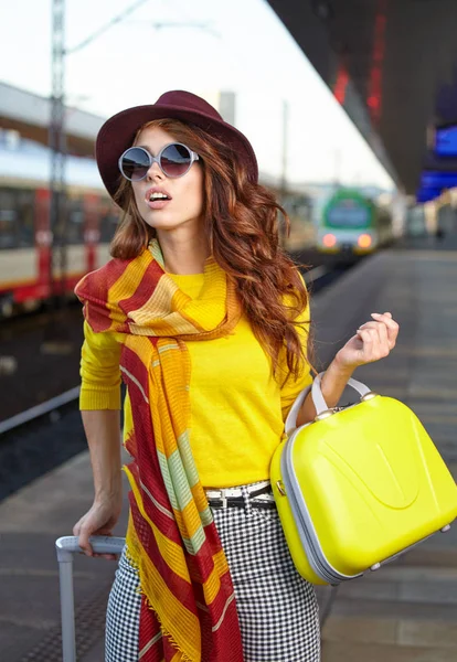 Mujer joven y bonita en una estación de tren (imagen tonificada otoño ) — Foto de Stock