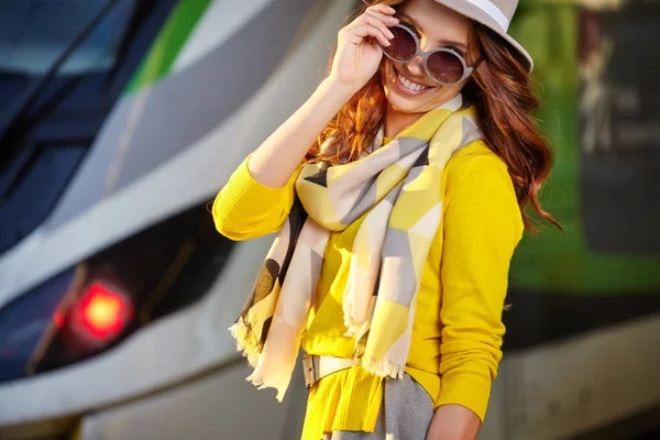 Hübsche junge Frau an einem Bahnhof (herbstliches Bild)) — Stockfoto