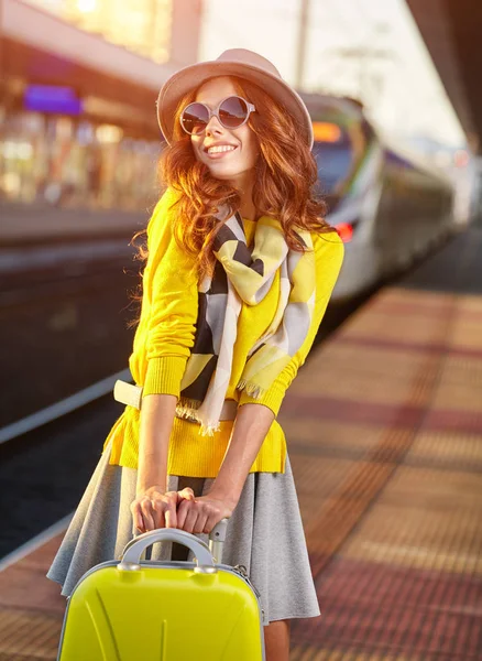 Mujer joven y bonita en una estación de tren (imagen tonificada otoño ) — Foto de Stock