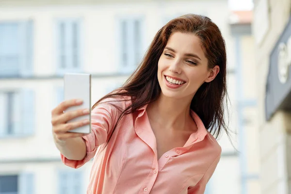 Front view of a fashion happy woman walking and using a smart ph — Stock Photo, Image