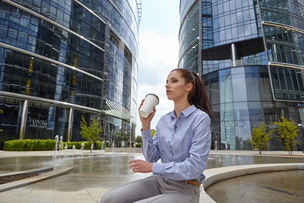 Frau genießt Kaffee vor dem Bürogebäude — Stockfoto