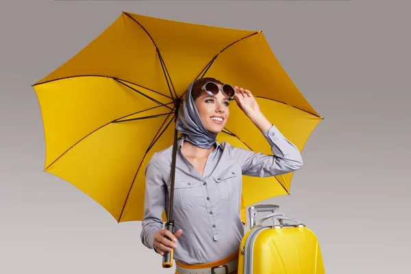 Glamour woman with yellow umbrella and suitcase. Travel concept — ストック写真