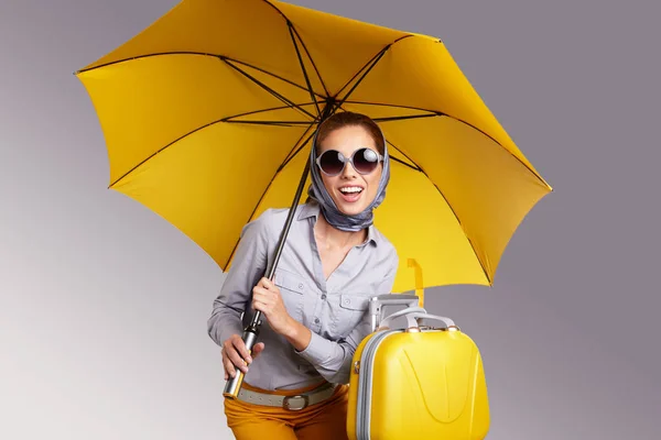 Mulher glamour com guarda-chuva amarelo e mala. Conceito de viagem — Fotografia de Stock