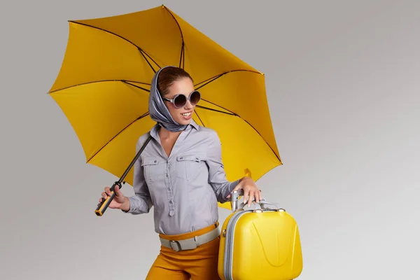 Mujer glamour con paraguas amarillo y maleta. Concepto de viaje —  Fotos de Stock