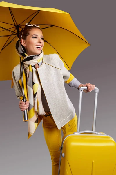 Glamour woman with yellow umbrella and suitcase. Travel concept — Stock Photo, Image