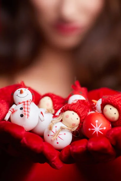 Pequeno boneco de neve com cachecol vermelho e chapéu nas mãos de um modelo . — Fotografia de Stock